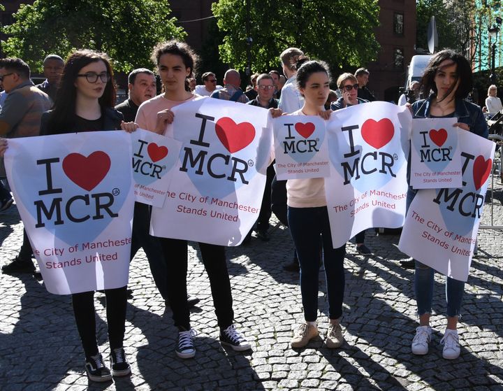 People hold placards reading 'I love Manchester' as they take part in a commemoration ceremony held for explosion victims of Manchester Arena stadium, at Albert Square in Manchester, United Kingdom on May 23, 2017.