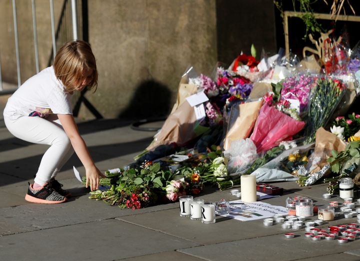 A girl leaves flowers for the victims of an attack on concert goers at Manchester Arena, in central Manchester, Britain May 23, 2017. REUTERS/Peter Nicholls