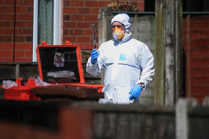 A police forensic investigator examines an address in Elsmore Road, linked to Adedi