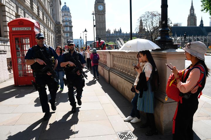 Tourists stand aside as two armed officers stride through Westminster on Wednesday