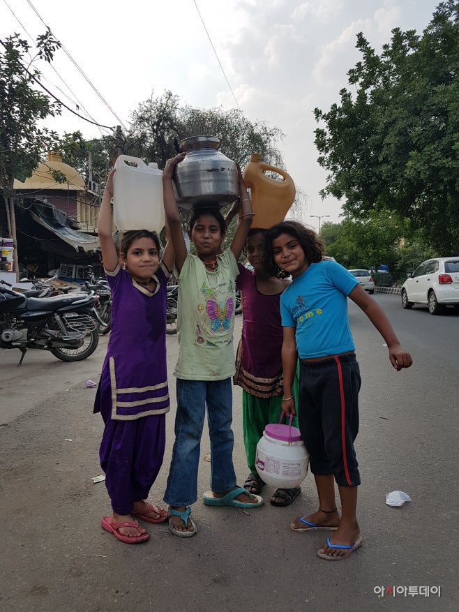Girls are carrying big water buckets on their heads in Tamil Sangnam, New Delhi. However, some of them failed to fill their b