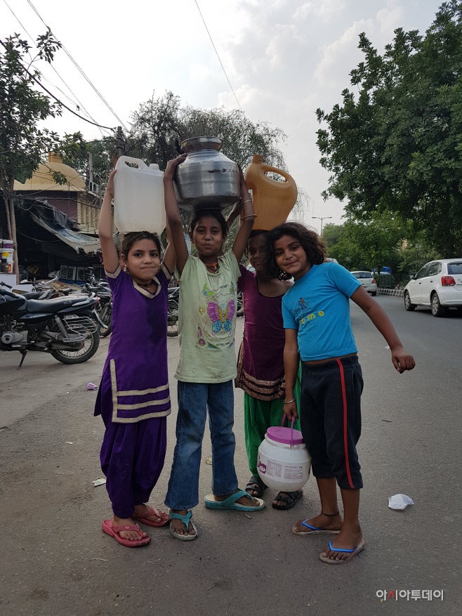 Girls are carrying big water buckets on their heads in Tamil Sangnam, New Delhi. However, some of them failed to fill their buckets with water./ Photographed by Jeong In-seo 