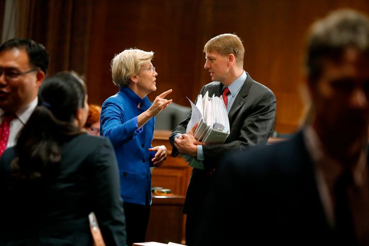 Sen. Elizabeth Warren (D-Mass.) talks with Consumer Financial Protection Bureau Director Richard Cordray after he testified on Capitol Hill on Wall Street reform in 2014. Warren pushed for the creation of the bureau.