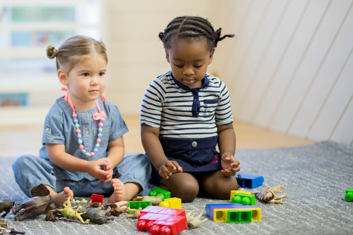 A group of toddlers are playing with toys together in preschool. FatCamera via Getty Images