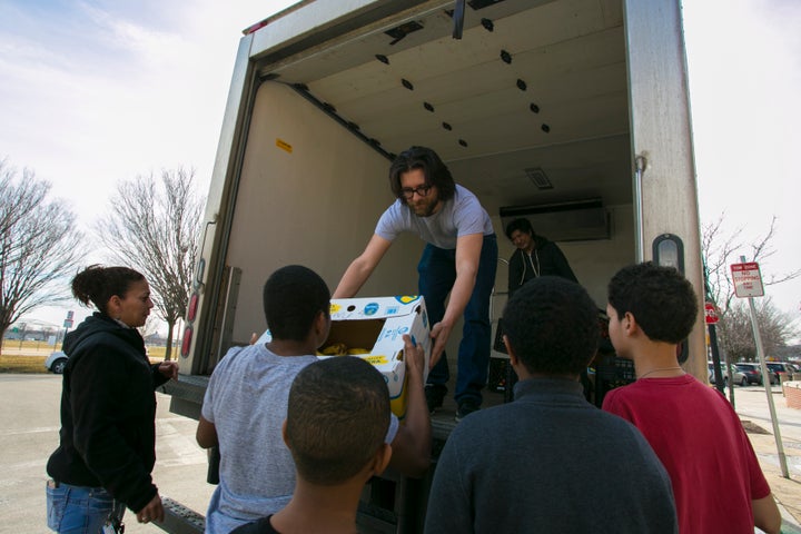 <p>Lovin’ Spoonfuls driver Vinny Vassallo distributes food to a beneficiary in South Boston</p>