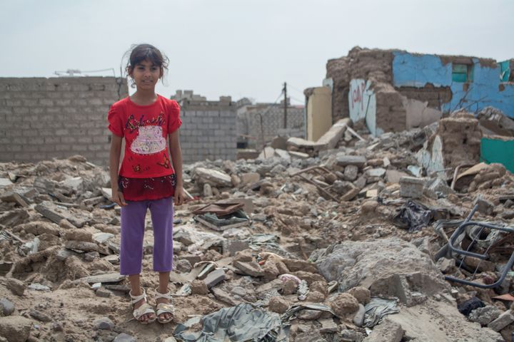 Zahra stands in the rubble at her destroyed home, in the south-western city of Lahj, Yemen, which has experienced intense fighting due to the escalation of conflict in the country.
