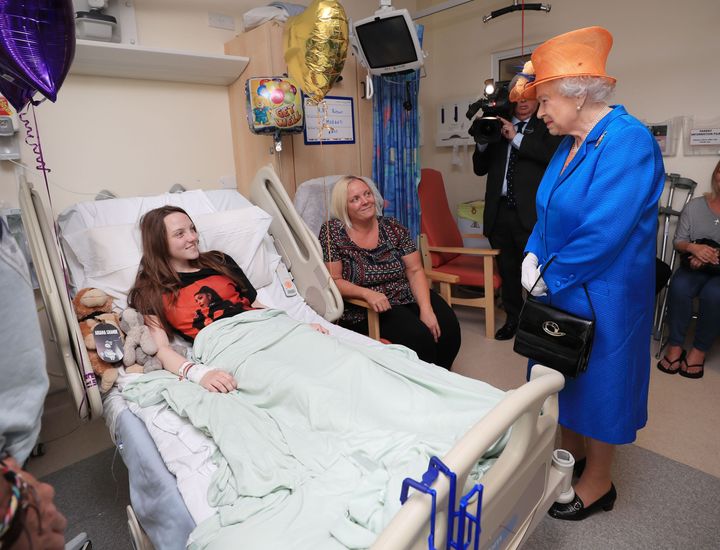 Queen Elizabeth II speaks to Millie Robson, 15, from Co Durham, and her mother, Marie, during a visit to the Royal Manchester Children's Hospital to meet victims of the terror attack in the city earlier this week and to thank members of staff who treated them.