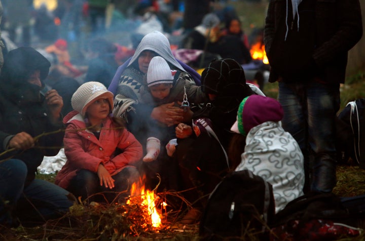 Families fleeing violence in Syria, here huddled around a fire at a makeshift camp in Slovenia in 2015, are easy prey for extremists who promise food, shelter and adventure.