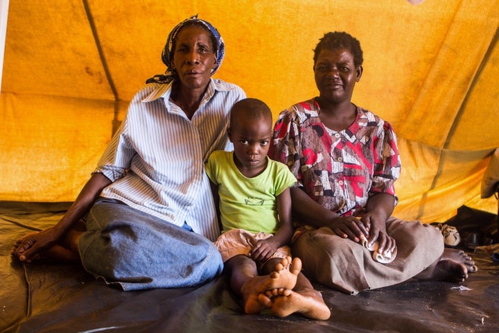 Jeselina Masuku, 67, (left) sits next to Sinokwethu Moyo, 7, and Thokozani Ncube, 48. Both Ncube and Masuku are anxious to le