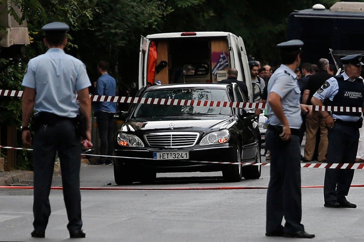 Police secure the area around the car of former Greek prime minister and former central bank chief Lucas Papademos following the detonation of an envelope injuring him and his driver, in Athens, Greece, May 25, 2017.