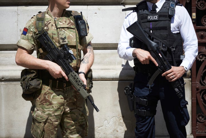 A British army soldier and police officer are stationed in London as Britain raises its terror alert following the attack in Manchester. 