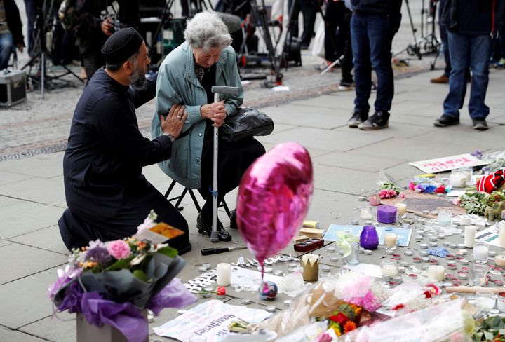 A Muslim man named Sadiq Patel comforts a Jewish woman named Renee Rachel Black next to floral tributes in Albert Square in Manchester, Britain May 24, 2017.