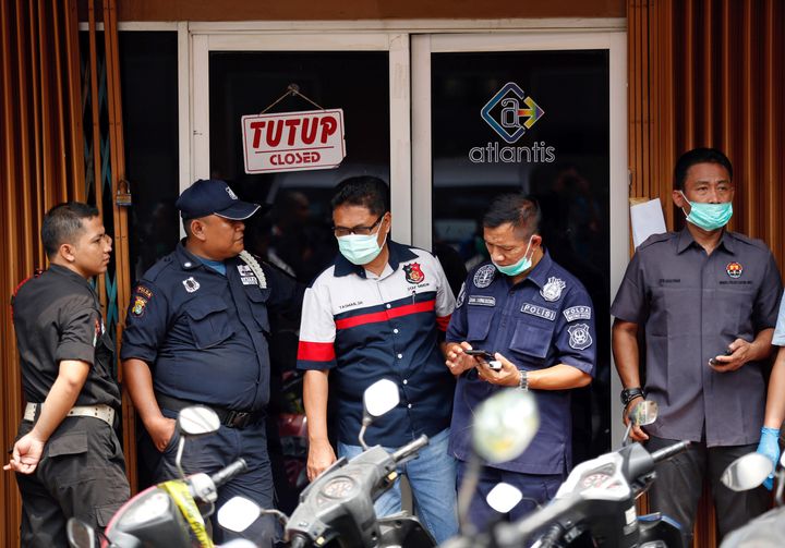 Police are seen outside the club where 141 men were detained for what was described as a gay prostitution ring in Jakarta. 