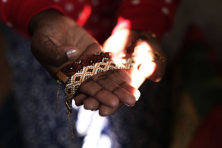 An artisan in rural Nepal presents her beaded bracelets. 