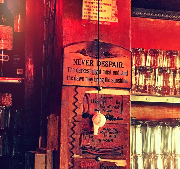 A sign behind the bar at Sunny’s: “NEVER DESPAIR - The darkest night must end, and the dawn may bring the sunshine.”