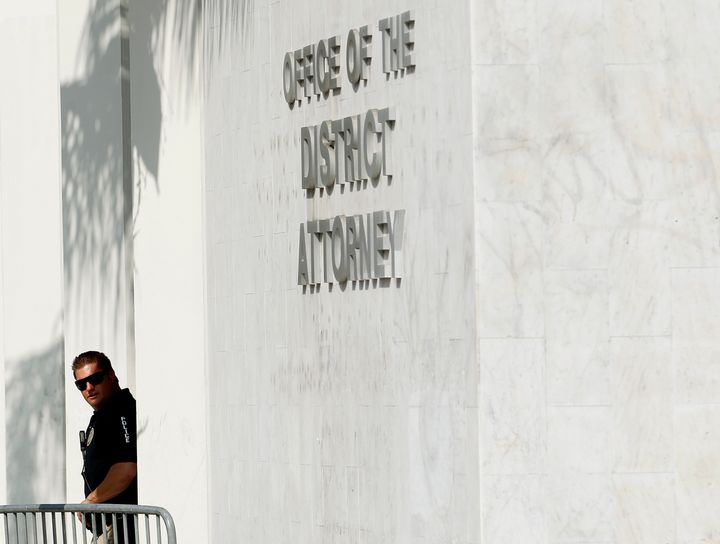 A policeman looks out of the Orange County District Attorney's building.