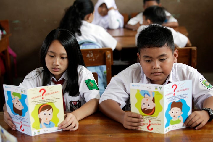 <p>Boys and girls reading MHM comic during MHM intervention.</p>
