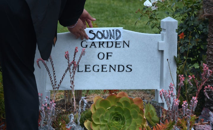 Kanan Sanchez places a folded sheet of paper with the word 'Sound' over the stone at the Garden of Legends section of the Hollywood Forever Cemetery where Soundgarden frontman Chris Cornell was buried at a funeral service in Los Angeles, California on May 26, 2017.