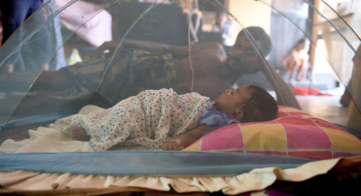 A Sri Lankan child and man rest at a relief camp after being evacuated following flooding. 