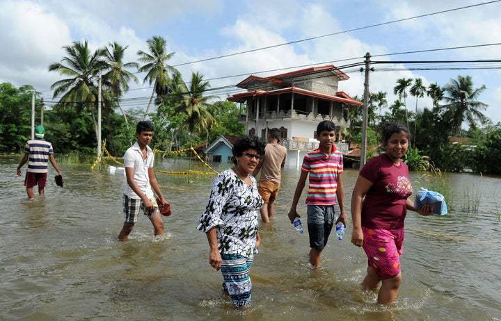 Sri Lankan residents walk through floodwaters in Kalutara. 