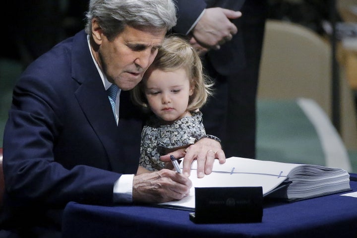 Then-Secretary of State John Kerry holds his 2-year-old granddaughter as he signs the Paris Agreement on climate change at United Nations Headquarters in New York City on April 22, 2016.