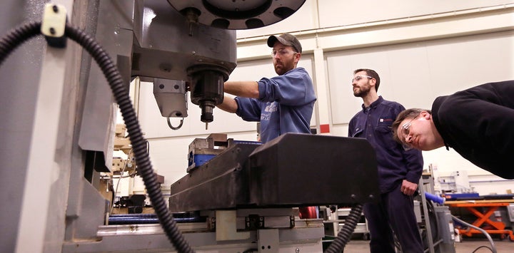 A student learns to operate a mill in an advanced precision machining class.