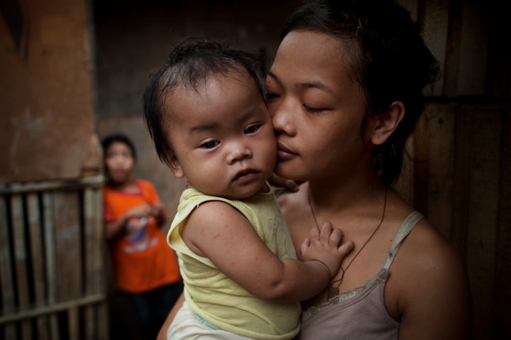 A 14-year-old girl carries her 10-month-old baby in Cagayan de Oro in the Philippines, where abortion is illegal and the Catholic Church continues to pit itself against the use of contraceptives.