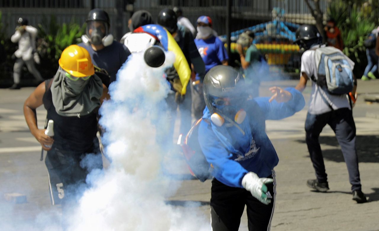 A demonstrator throws a tear gas canister during clashes with riot security forces at a protest against Venezuelan President Nicolas Maduro's government in Caracas, Venezuela, on May 30.
