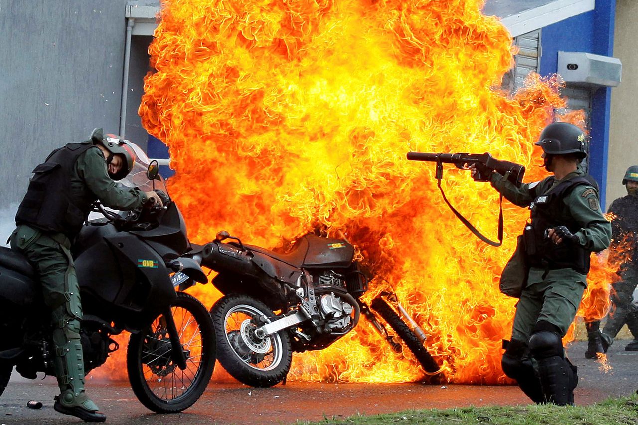 Riot security forces clash with demonstrators as a motorcycle is set on fire in San Cristobal, Venezuela, on May 29.