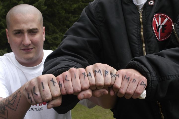 Jacob Laskey, left, and another skinhead member of Volksfront from Oregon, show off their tattoos while attending the 2003 Aryan Nations World Congress held on June 22, 2003 in Hayden, Idaho.