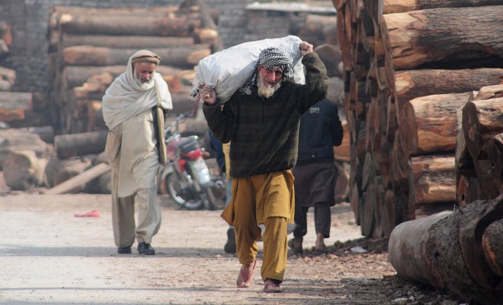 An elderly Afghan refugee carries a sack in a slum neighborhood for refugees in Islamabad, Pakistan, on Feb. 8. Pakistan's government has extended a deadline for Afghan refugees to leave the country until the end of 2017.