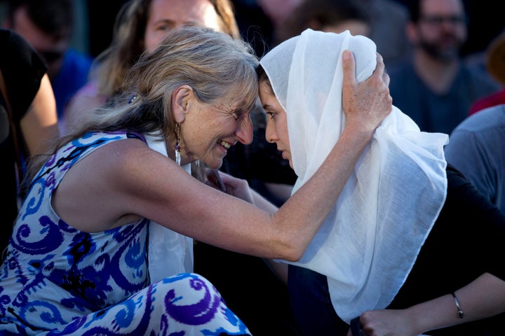Asha Deliverance, left, the mother of Taliesin Myrddin Namkai-Meche, leans in and embraces a woman who approached her at the