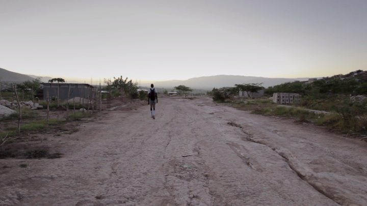 <p>Pierre Joseph walking on the outskirts of Port-Au-Prince, Haiti to the basketball court</p>