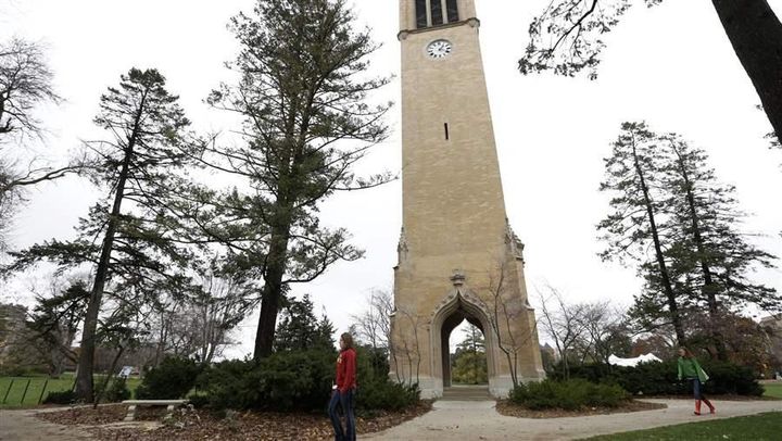 Students walk past the campanile at Iowa State University. Iowa State is among the universities that charge higher tuition to students in certain programs.