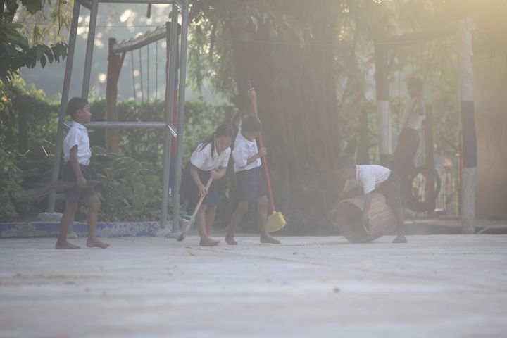 Students take turns cleaning their school playground early in the morning as soon as they arrive at school. Location: Spean Chreav Amelio Primary School, Siem Reap.