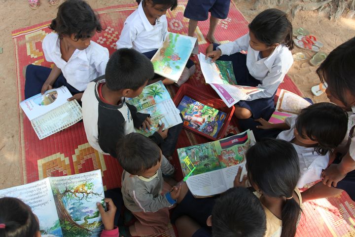 Instead of playing, some students borrow books and a mat and read outside in a group. Location: Bakong Motwani Junior High School, Siem Reap. 