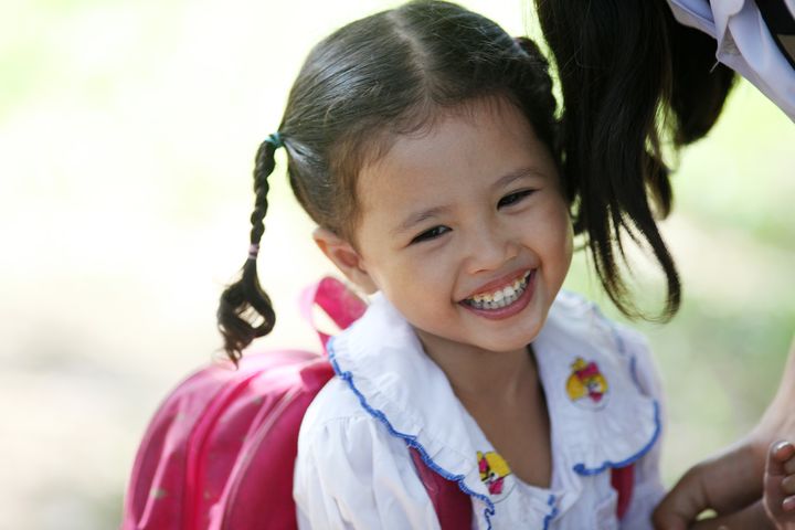 A schoolgirl enjoying school recess. Location: Spean Chreav Amelio Primary School, Siem Reap.