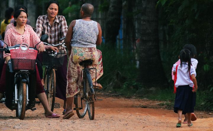 Adults and students pass each other again on their ways home after work and school. Location: Spean Chreav Amelio Primary School, Siem Reap.