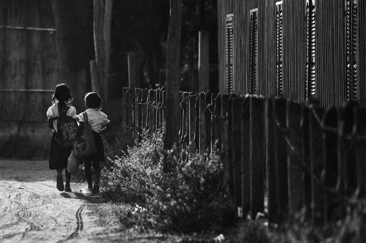 Two elementary school students heading home after a long day of school. Location: Aranh Sakor CFC Primary School, Siem Reap.