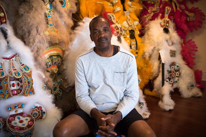 Darryl Montana sits at home in front of several suits he created during previous years. 