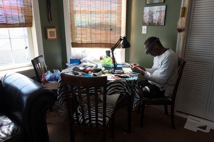 Darryl Montana works on his Carnival suit in his workroom. He estimates that it takes over 5,000 hours per year to complete and he spends thousands of dollars on materials. The work is tedious and solitary. Darryl wears a special pair of magnifying glasses handed down to him from his father. 