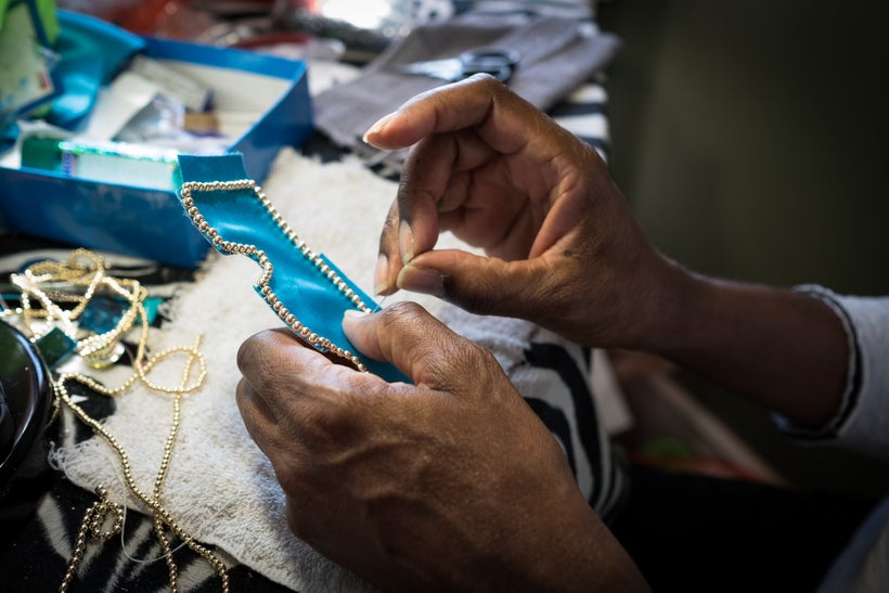 Darryl Montana sews beads onto his suit.