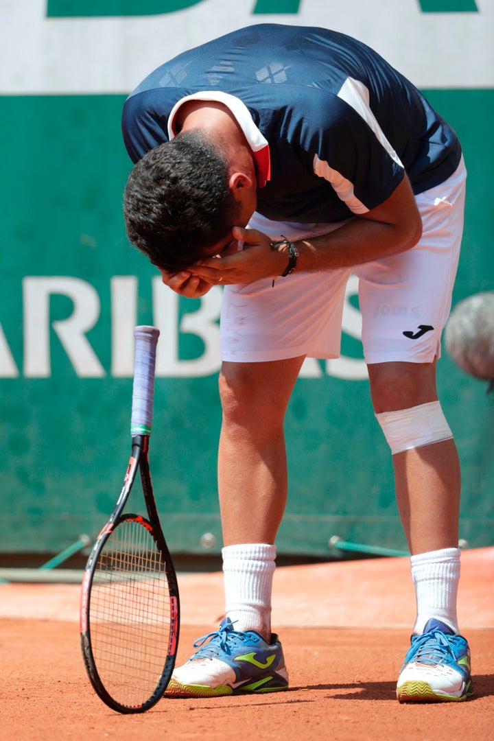 Almagro reacts as he realizes he can't finish the match. The player has been fighting a recurring knee injury.