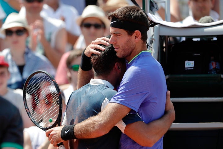 Spain's Nicolás Almagro, left, is comforted by Argentina's Juan Martín del Potro as a knee injury forces him to