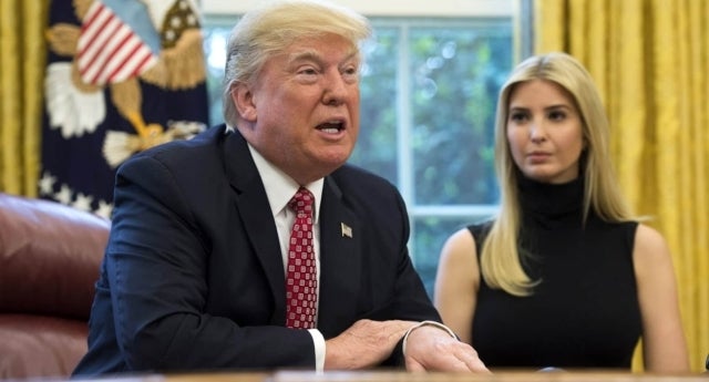 President Trump is in the foreground and his daughter Ivanka behind him to his right. He is wearing a suit with a red tie and