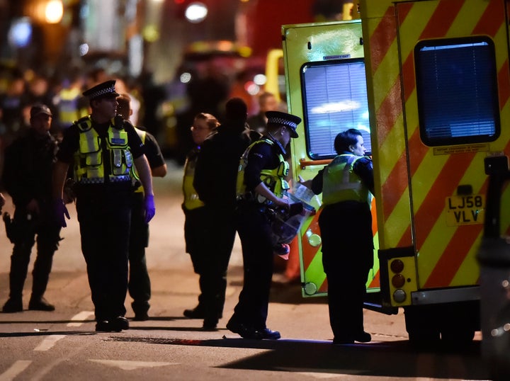 Police officers speak with ambulance personnel after Saturday night's terror incident near London Bridge.