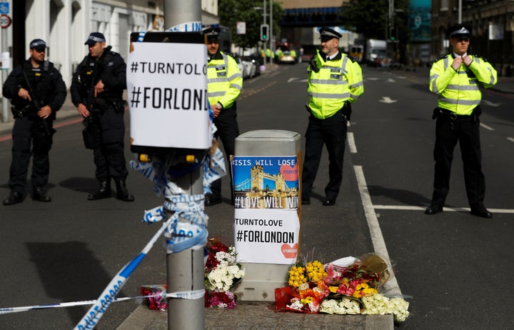 Flowers and messages lie behind police cordon tape near Borough Market after an attack left seven people dead and dozens injured in London over the weekend. 