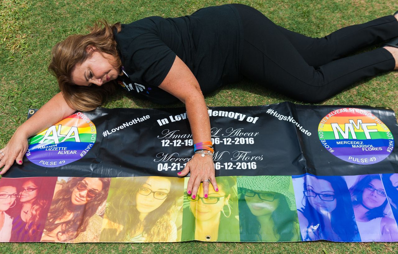 Mayra Alvear poses with a banner she made for her daughter Amanda Alvear and Mercedez Flores both killed in the Pulse nightclub shootings last year.