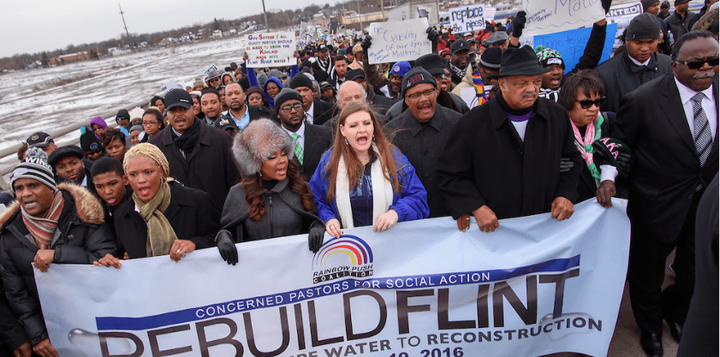 Flint residents march along Stewart Avenue with the Flint resident and community activist Melissa Mays, center, Rev. Jesse Jackson, members of his Rainbow PUSH Coalition, the Michigan Legislative Black Caucus, and the Concerned Pastors group Friday February 19, 2016 on Flints north side. 