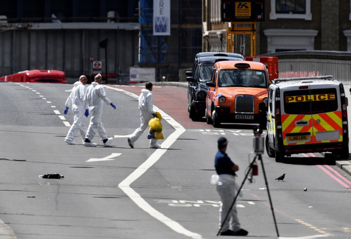 Police forensic investigators comb the scene after the attack 